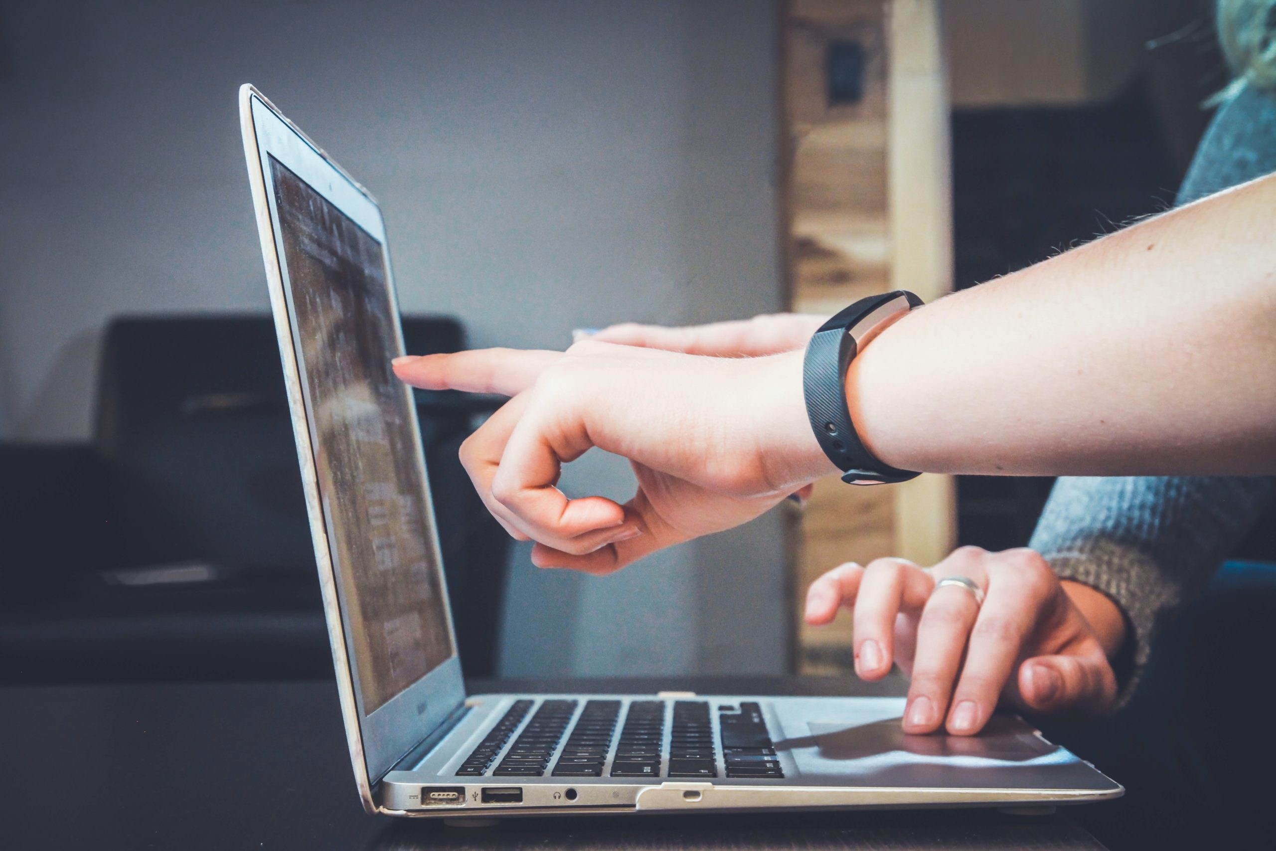 duas pessoas de frente par aum laptop apontando para a tela com objeções de vendas